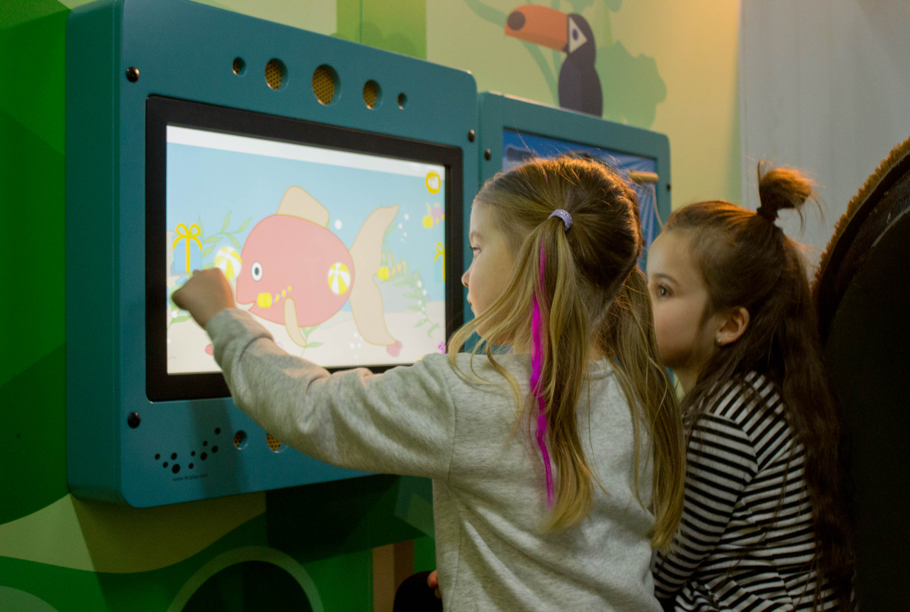 dwoje dzieci bawiących się na interaktywnych systemach zabawowych IKC
